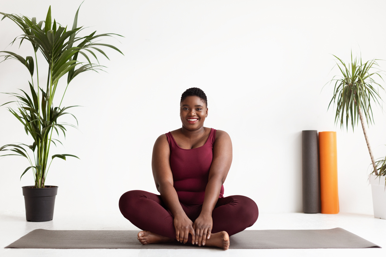 Happy black woman plus size practicing yoga
